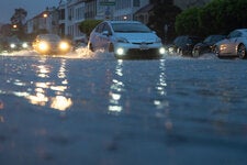 Drivers splash through floods in San Francisco on Friday.